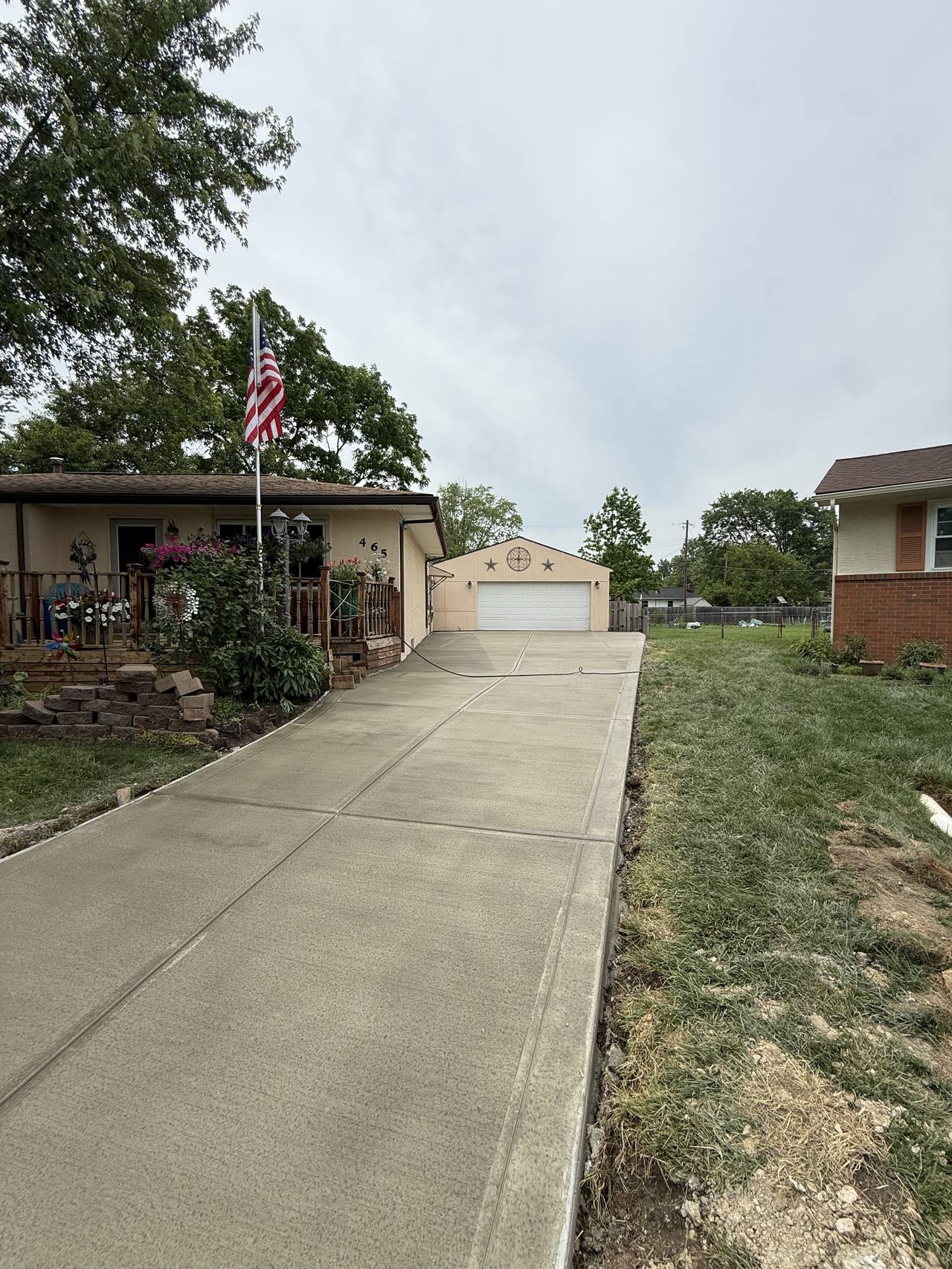 Broom-finish concrete driveway leading to a two-car garage