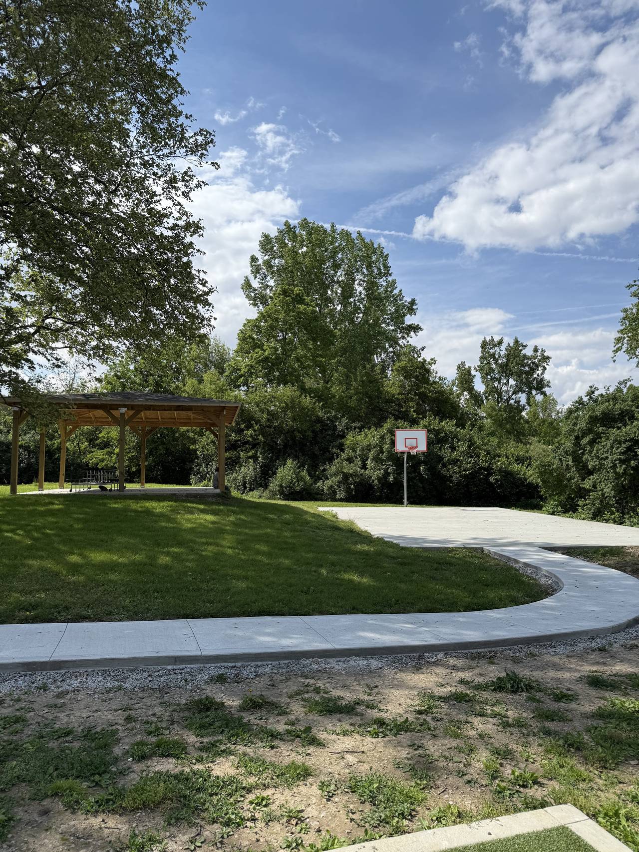 Community pavilion, curved concrete sidewalk, and basketball court slab for a property management client