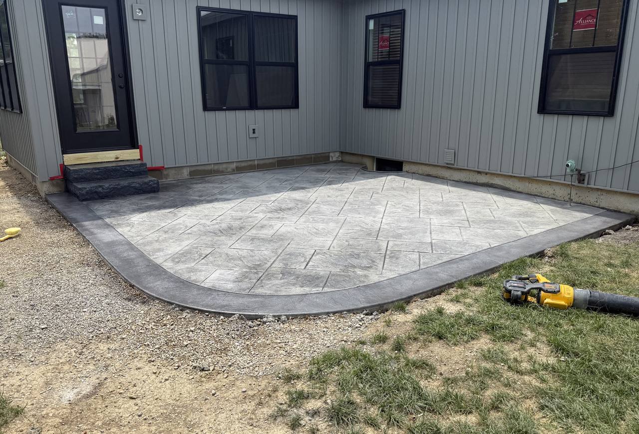 Stamped concrete patio with curved dark gray border